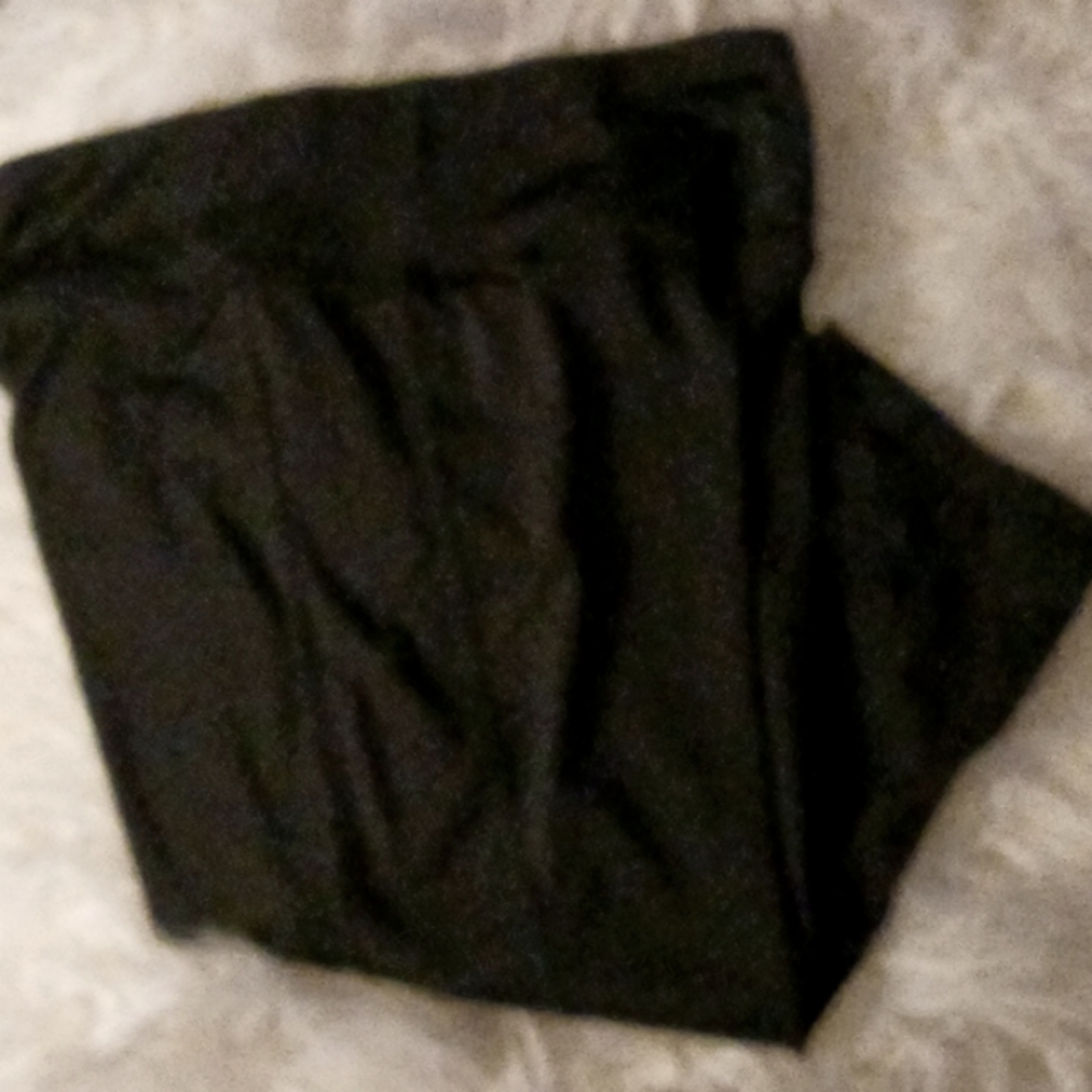 Black knee length stretch pants with criss cross design on sides of legs. Origin